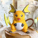 Lovely Pokémon Figure of Raichu sitting on a wooden display with a decorative background.